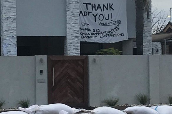A family leaves a thank you sign for volunteers in Echuca as the town prepares for the flood.