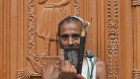 A Hindu holy man displays the indelible ink mark on his index finger after casting his vote in the seventh and final phase of national elections in Varanasi, India. 