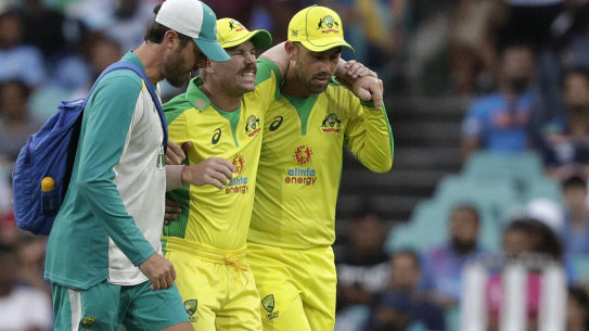 David Warner is helped from the field by David Beakley and Glenn Maxwell during the second ODI.