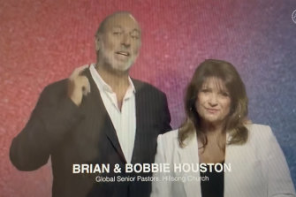 Brian Houston, flanked by his wife, Bobbie, tells the church's faithful that he was stepping down to prepare to defend court charges that he concealed information about allegations of his father's sexual abuse.