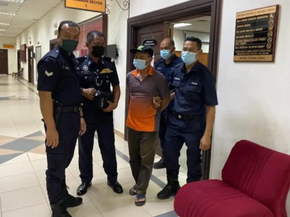 Alladin Lanim is escorted by Malaysian police during a court appearance in Kuching in August.