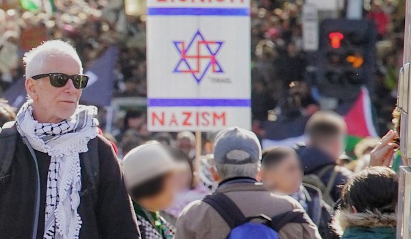 Pro-Palestine protesters march through Melbourne last March, one carrying a sign juxtaposing Zionism and Nazism.