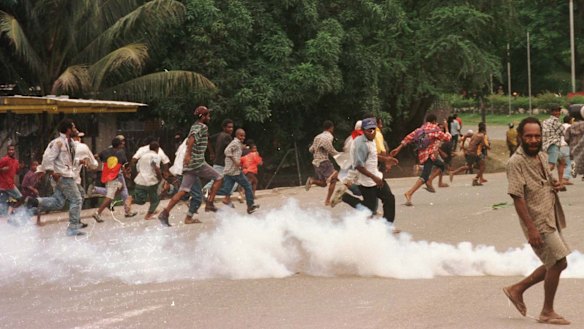 Rioters flee as soldiers disperse the crowd with tear gas and live rounds.