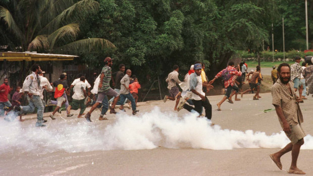 Rioters flee as soldiers disperse the crowd with tear gas and live rounds.