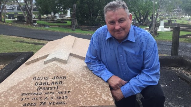 Historian Peter Collins at Canon Garland's grave at Toowong Cemetery.