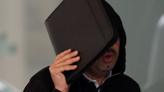 Tobacco tycoon Muh’d Alzoubi hid his face behind an ipad as he left Downing Centre Local Court on Friday.