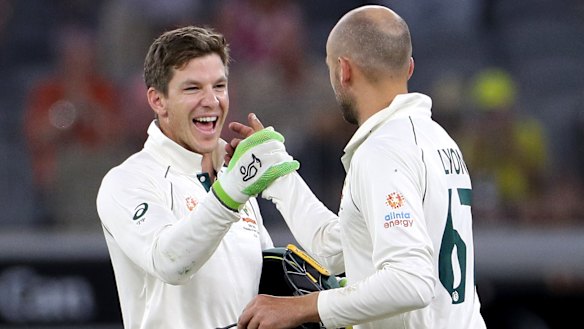 Over and out: Tim Paine and Nathan Lyon celebrate victory on night four, after the Australian spinner claimed the final New Zealand wicket to complete the win.