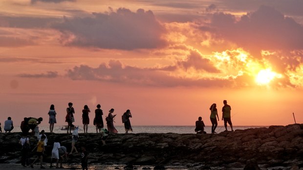 Chinese tourists watch the sunset in Kuta.