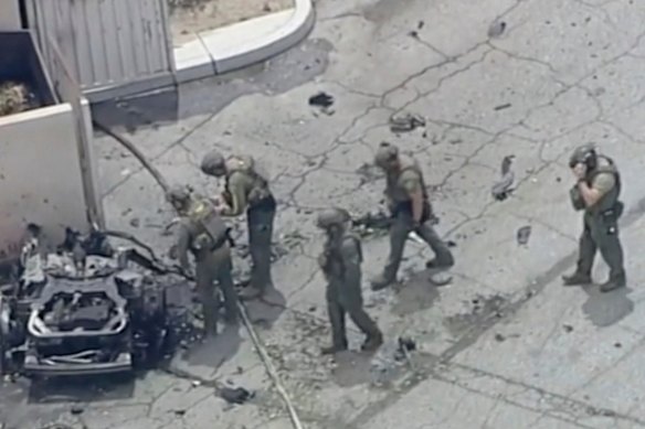 Law enforcement investigate a vehicle after the explosion.
