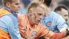 A bleeding Tom Glover of Melbourne City is escorted from the pitch.