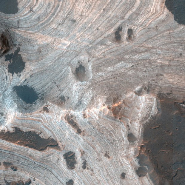 Much of Mars is covered by sand and dust but in some places, such as Holden Crater, stacks of sedimentary layers are visible.
