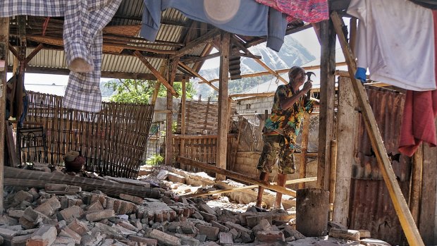 A man tries to fix a roof damaged by the earthquake in Sembalun Bumbung, east Lombok.