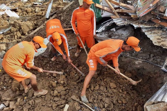 National Disaster Response Force personnel search through the debris after a mudslide in Noney, north-eastern Manipur state, India.