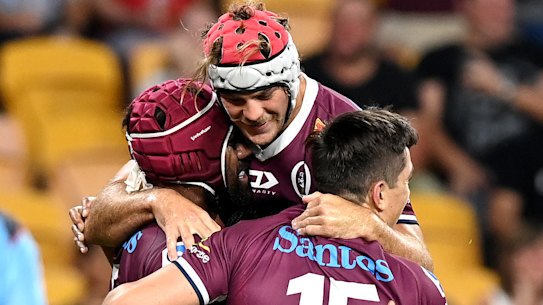 Jock Campbell is congratulated by Reds teammates after scoring a try against the Waratahs.