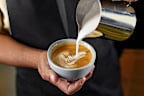 Barista making a cup of coffee latte art