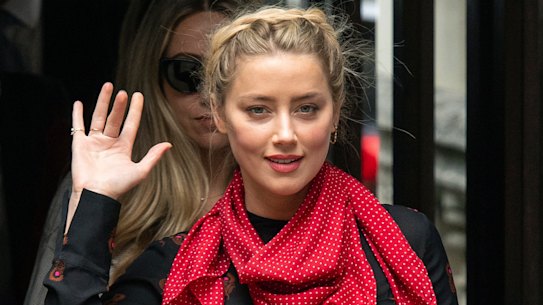 Actress Amber Heard gestures as she arrives at the High Court for a hearing in Johnny Depp's libel case, in London on Wednesday.