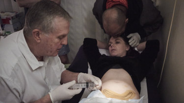 Dr George O'Neil anesthetises Jessica Martin's abdomen before implanting the drug naltrexone.