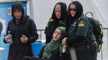 A woman is overcome at the first funeral of the 50 victims of the Mosque shootings at the Memorial Park Cemetery.