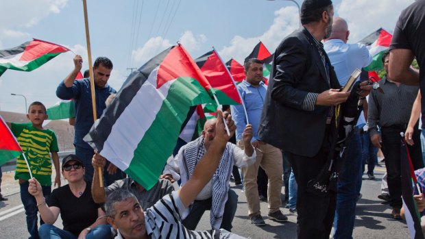 Protesters fly Palestinian flags and chant anti Israel slogans.