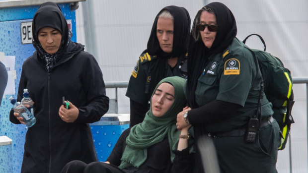 A woman is overcome at the first funeral of the 50 victims of the Mosque shootings at the Memorial Park Cemetery.