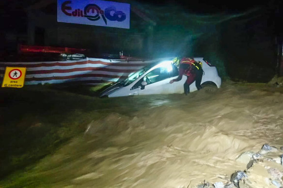 A firefighter next to a partially submerged car after heavy rains caused flooding in the town of Limone Piemonte, Italy. At least two people have died and at least 25 are missing after the storm hit France and Italy.
