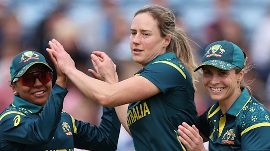 Ellyse Perry of Australia celebrates with teammates Alana King (left) and Sophie Molineux.
