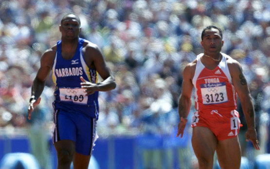 Tolutau Koula (right) competes in a 100m heat at the Sydney Olympic Games in 2000.