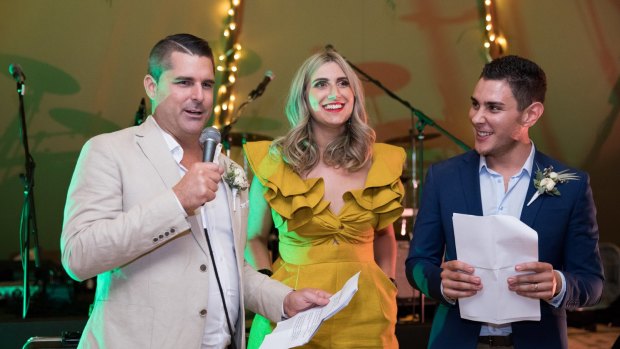 Shane Newcombe (left) and Ethan Tyler (right) at the Sandstone Point Hotel for their 2018 wedding, with mayor Allan Sutherland's then-executive officer Corinne Mulholland, who performed MC duties.