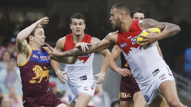 Tamed: Lewis Taylor of the Lions attempts to tackle Lance Franklin of the Swans.