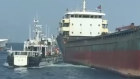In this photo made from video released by the Taiwan Coast Guard, Taiwanese Coast Guard vessels prepare to board Togolese-flagged cargo ship Hongtai suspected of severing an undersea communications cable in waters between its main island’s west coast and the outlying Penghu islands. 