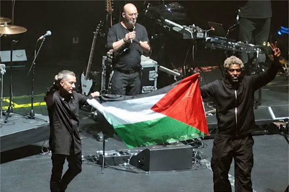 Members of British band Massive Attack unfurl a Palestinian flag and chant “Free Palestine” during their July 29, 2026 concert in Singapore.