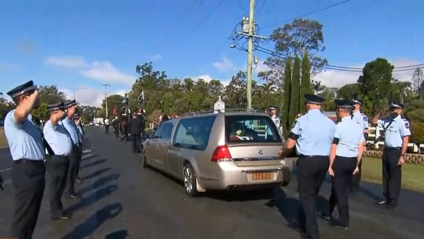 Senior Constable Dave Masters’ coffin is driven from the funeral home to the nearby sport field.