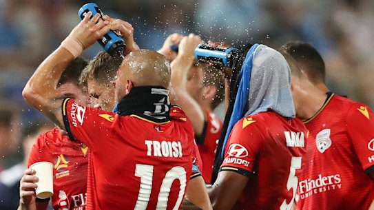 Adelaide players take a drinks break during the match with Sydney FC on Saturday night. 