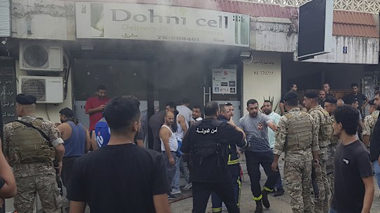 Soldiers and firefighters gather outside a mobile shop after what is believed to be the result of a walkie-talkie exploding inside it, in the southern port city of Sidon, Lebanon.