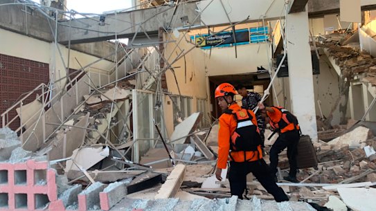 Rescuers search for victims at a damaged building in Maumere, East Nusa Tenggara Province, Indonesia, following the earthquake,