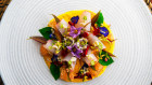 Lum Orng’s raw fish, pomelo, edible flowers and herbs in a yellow emulsion.