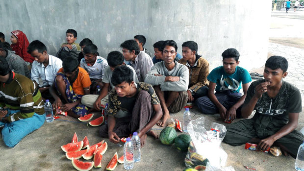 People who claim to be Rohingya Muslims eat food, in Krabi province,  Thailand, on Sunday before their boat was helped back to sea by Thai fishermen and navy craft after being damaged in a storm.