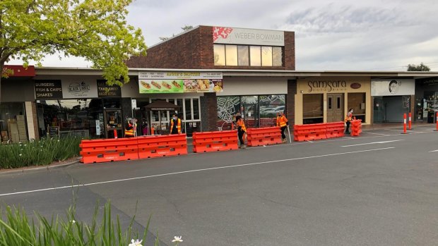 Workers set up new outdoor dining areas for restaurants trading at Pinewood Shopping Centre in Mount Waverley.
