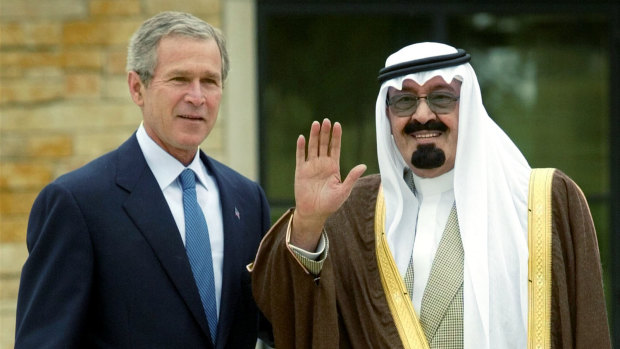 President Bush, left,  poses with a waving Saudi Crown Prince Abdullah, right, after the latter's arrival at Bush's ranch in Crawford, Texas, in 2002.