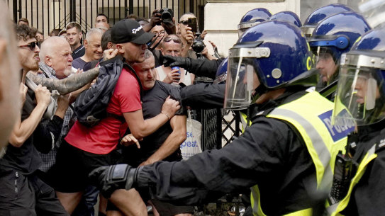 Protesters scuffle with police during the "Enough is Enough" protest in Whitehall, London, Wednesday July 31, 2024, following the fatal stabbing of three children at a Taylor Swift-themed summer holiday dance and yoga class on Monday in Southport. (Jordan Pettitt/PA via AP)