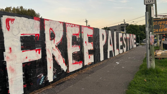 The freshly painted sign conceals a tribute to Israeli hostages erected in the heart of Melbourne’s Jewish community.