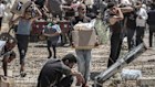 Palestinians collect humanitarian aid from a distribution centre in the Netzarim Corridor.