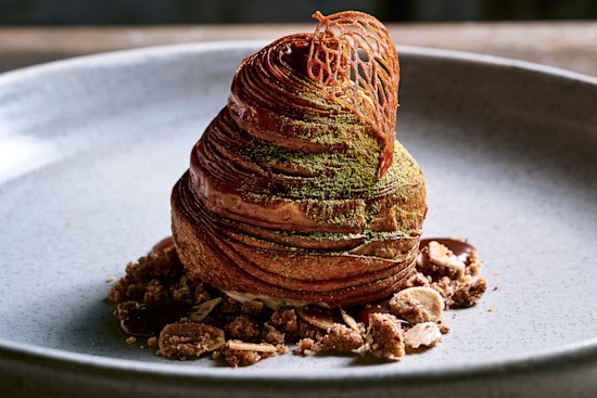 Pear monaka, a pear-shaped croissant brushed with amaretto syrup and filled with pear compote and hojicha ice-cream. It rests on a bed of dulcey whipped ganache, ginger caramel and brown butter crumble.