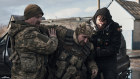 Ukrainian soldiers help a wounded comrade into an evacuation vehicle near the front line in Bakhmut, Donetsk.