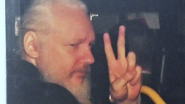 Julian Assange gestures as he arrives at Westminster Magistrates' Court in London.