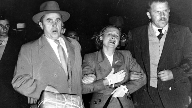 Two Soviet KGB agents ‘escort’ Evdokia Petrov across the tarmac at Sydney Airport in April 1954 .