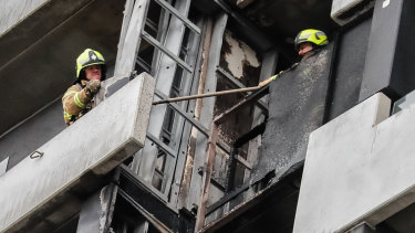 Firefighters inspect the damage from a blaze in Melbourne's Neo200 building.