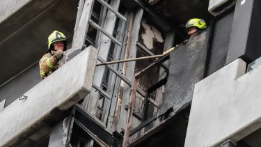 Firefighters survey the damage on the Neo 200 tower block in Melbourne's Spencer Street.