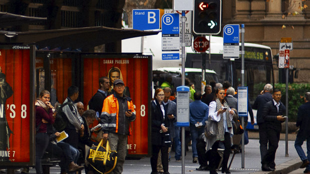Commuters wait in hope for buses outside the QVB in Sydney.