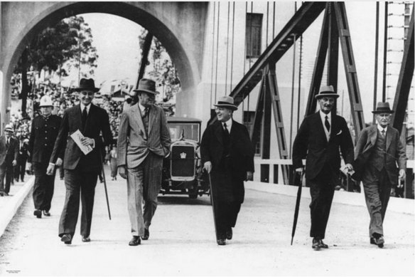Then Queensland governor Sir Leslie Orme (far left) crosses the Indooroopilly Toll Bridge on its opening day in 1936 with its designer, Walter Taylor (far right).